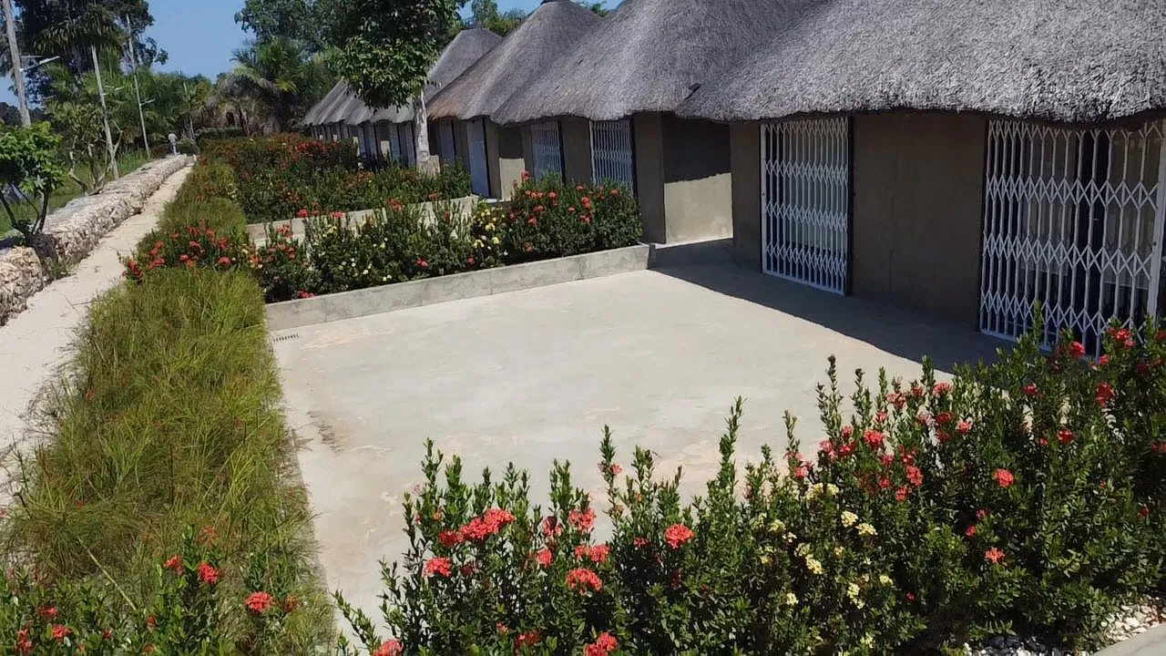 Riverside chalet walkway lined with garden hedges and flowering shrubs
