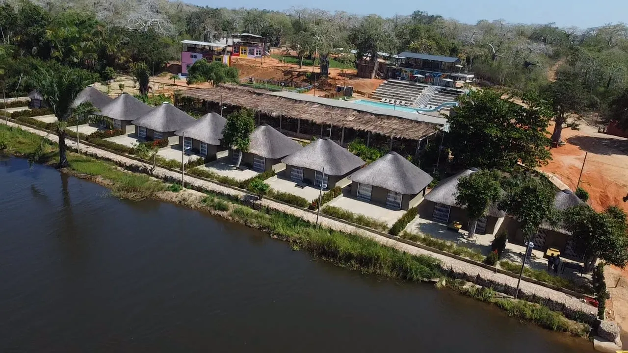 Aerial view of the resort's chalets, pool deck and canopy restaurant beside the river