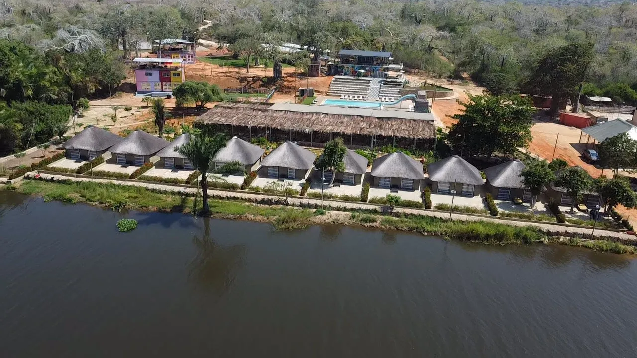 Aerial view of the full resort grounds with pool, chalets and surrounding forest