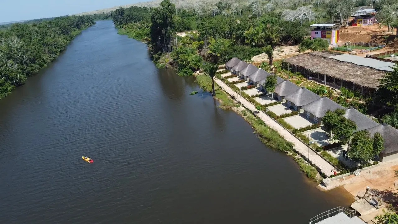 Aerial view of a kayaker on the Kwanza River beside the resort's riverside chalets